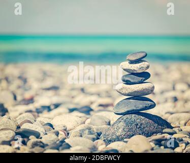 Zen meditazione sfondo - effetto retrò vintage filtrato stile hipster immagine di pietre equilibrate impilate da vicino sulla spiaggia di mare Foto Stock