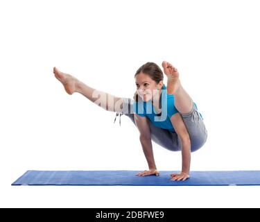 Yoga - giovane bella donna istruttore yoga facendo Firefly asana pongono (Titibasana) esercizio isolato su sfondo bianco Foto Stock