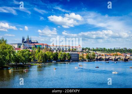 Fiume Moldava e Gradchany Castello di Praga, Cattedrale di San Vito e Ponte Carlo con persone in pedalò. Praga, Repubblica Ceca Foto Stock