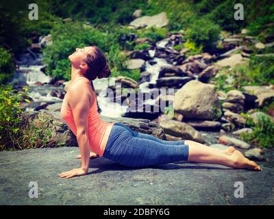 Yoga Outdoors - le pratiche della donna Ashtanga Vinyasa yoga Surya Namaskar Sun Salutation asana Urdhva Mukha Svanasana - la posa del cane rivolta verso l'alto. Vintage re Foto Stock