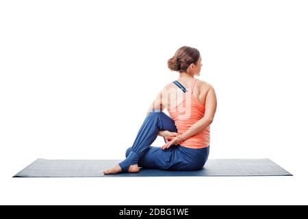 Bella sport fit donna pratica yoga asana Ardha matsyendrasana - posa di torsione spinale a metà isolato su bianco Foto Stock