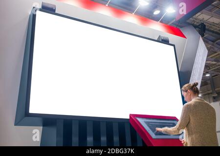 Mockup immagine - donna guardando il vuoto bianco parete grande display Foto Stock