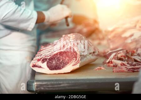 Macellaio che taglia carni bovine di wagyu nel macello Foto Stock