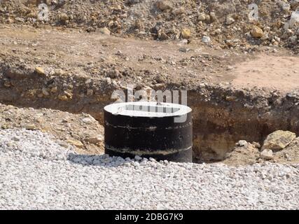 Una costruzione di botole fognarie. Installazione fognature. Foto Stock