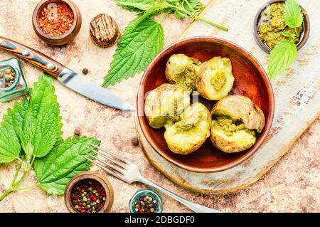 Patate al forno farcite con erbe e foglie di ortica Foto Stock