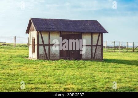 Vecchio fienile sul campo erboso verde nel campo di concentramento e sterminio tedesco Majdanek. Lublino, Polonia Foto Stock