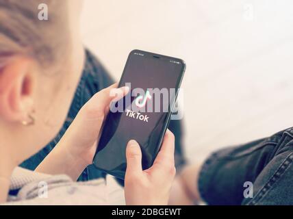 KIEV, UCRAINA-GENNAIO, 2020: Tiktok sullo schermo del telefono intelligente. Young Girl punta o texting Tiktok su smartphone durante un Pandemic Self-Isolation e C. Foto Stock