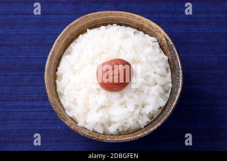 Cibo giapponese, Umeboshi sottaceto di sale prugna su riso bianco in una ciotola, vista dall'alto Foto Stock