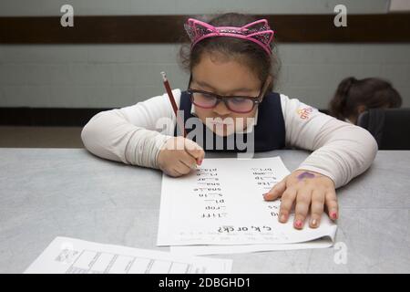Gli studenti delle scuole elementari lavorano sull'ortografia delle parole in un programma post-scolastico presso un centro comunitario di Manhattan, New York City. Foto Stock