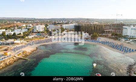 Vista aerea dall'alto della spiaggia di Vathia Gonia, Ayia Napa, Famagosta, Cipro. L'attrazione turistica punto di riferimento baia rocciosa all'alba con sabbia dorata, sole Foto Stock
