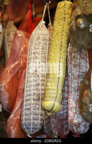 Differenti varietà di salumi appesi a un negozio di gastronomia Foto Stock