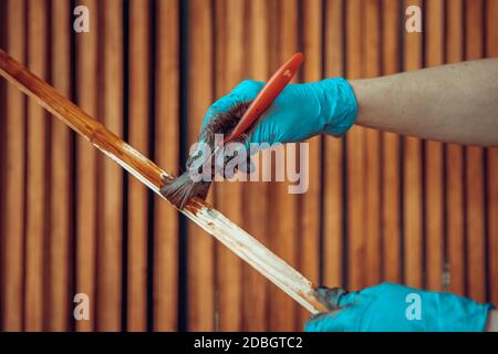 verniciatura di doghe di legno con rivestimento protettivo con tonalità cromatiche. Foto Stock