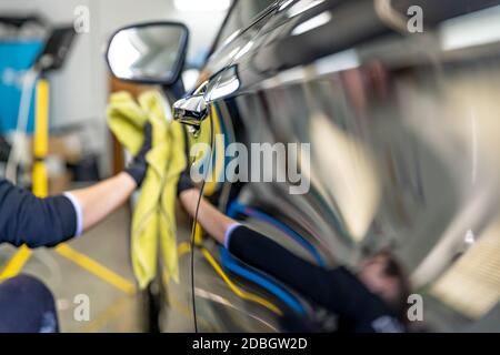 lucidare il corpo di auto di lusso con l'aiuto di un panno in microfibra per una perfetta brillantezza. Foto Stock