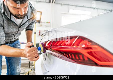 riparazione e lucidatura dei fari posteriori e della carrozzeria delle auto di lusso. Foto Stock