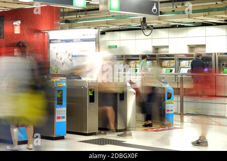 I passeggeri passano attraverso i tornelli nella stazione Tsuen WAN della Mass Transit Railway (MTR), Hong Kong Foto Stock