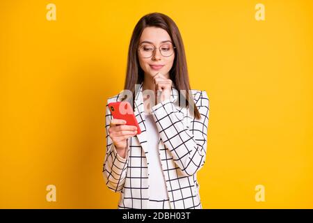 Ritratto fotografico di una donna d'affari curiosa che usa il viso a contatto con lo smartphone occhiali isolati su uno sfondo di colore giallo brillante Foto Stock