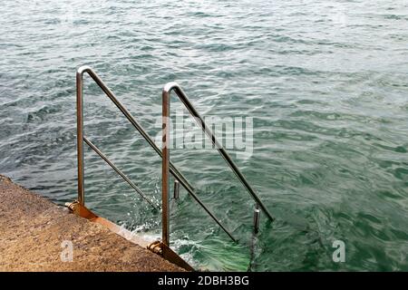 Scala metallica con corrimano per il mare Foto Stock