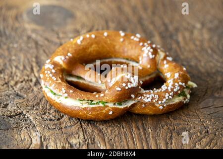 Pretzel bavarese con burro su legno Foto Stock