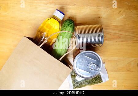 Approvvigionamento alimentare scorte alimentari crisi per il periodo di isolamento quarantena coronavirus su sfondo di legno. Consegna cibo, donazione. Vista dall'alto. Foto Stock