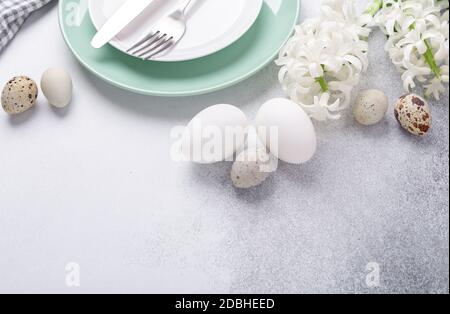 Leggera composizione pasquale. Piatto di menta verde, uova di pasqua, giacinto rosa e bianco su fondo di pietra. Concetto di Pasqua - immagine Foto Stock