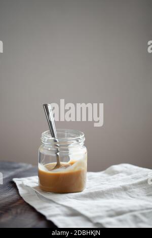 Dessert al budino di yogurt al gusto di caffè in vasetto di vetro su tavolo di legno. Stile di vita sano, supercibo Foto Stock