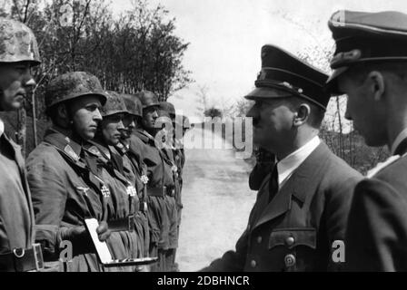 I comandanti del distacco paracadute di Wehrmacht ''Koch'' sono insigniti della Croce di Cavaliere della Croce di ferro da parte di Hitler per i loro successi nella battaglia di Fort Eben Emael. Sulla sinistra di fronte si trovano il capitano Walter Koch, leader del Battaglione di assalto Koch Parachute (Fallschirmjaeger-Sturm-Abteilung ''Koch'') e il suo primo tenente Rudolf Witzig. Quest'ultimo ricevette in seguito le foglie di quercia alla Croce del Cavaliere. Vi furono anche onorati il primo tenente Walter Kiess, il primo tenente Gustav Altmann, il sergente Hellmut Arpke, il tenente Egon Delica, Oberarzt (primo tenente (Dr.) Foto Stock