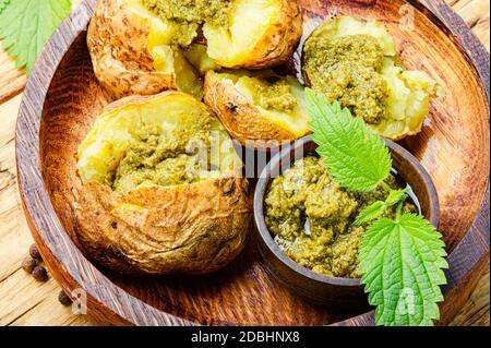 Patate al forno farcite con erbe e foglie di ortica Foto Stock