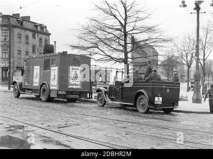 "Una campagna nazionalsocialista dotata di altoparlanti attraversa le strade di Berlino prima del secondo turno delle elezioni presidenziali del Reich. I manifesti elettorali dicono ''Donne! Vota per Adolf Hitler!'' Gli agenti di polizia seguono l'auto della campagna in un veicolo di scorta.' Foto Stock