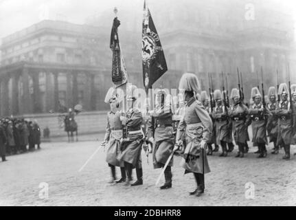 Marzo passato di una compagnia di bandiera dell'esercito tedesco durante la celebrazione di Capodanno a Berlino nel 1912. La bandiera e i battaglione sono del 1° Battaglione di un reggimento della Guardia Prussiana. Il portatore di bandiera (2° da destra) indossa un casco dell'artiglieria. Foto Stock