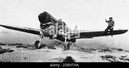 'Un pilota è seduto sull'ala del suo Curtiss P-40 ''Kittihawk''. La caratteristica è la ''bocca dello squalo'' dipinta. Foto Stock