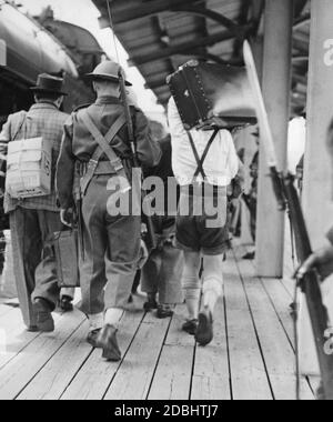 Un soldato canadese accompagna un gruppo di prigionieri di guerra tedeschi dopo il loro arrivo in Quebec. Foto Stock