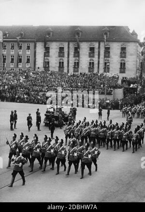 I membri degli Schutzpolizei, indossando le loro nuove divise per la parata, marciano davanti ad Adolf Hitler sulla piazza principale del mercato di Norimberga, con la banda di marcia davanti. Foto Stock