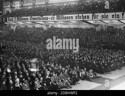 'Vista del pubblico durante un discorso di Joseph Goebbels al Berlin Sportpalast. Alcuni membri SA sono seduti sul pavimento. Un banner recita ''2 milioni di disoccupati - 65 milioni ancora in piedi per loro!''' Foto Stock