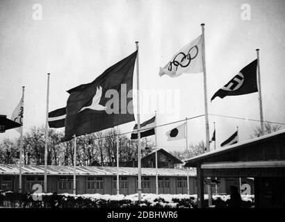 Alle Olimpiadi invernali di Garmisch-Partenkirchen, i giornalisti hanno tirato un panno nero con una grande anatra alla stampa tra le bandiere delle nazioni di fronte al centro stampa e il comitato organizzatore di Garmisch. Foto Stock