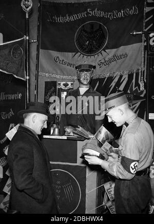 Nel Museo Revolutionsmuseum della Franzoesische Strasse di Berlino, gli organizzatori della mostra nazionalsocialista hanno diffamato i loro oppositori politici. Un uomo del Reichstanner Schwarz-Rot-Gold con la bandiera corrispondente. In primo piano è un membro della SA e un visitatore civile. Foto Stock