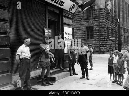 Nell'angolo tra Jueden e Parochialstr. A Berlino, gli organizzatori della mostra nazionalsocialista hanno diffamato i loro oppositori politici. Vista del museo dall'esterno. Di fronte al museo si trova una figura di una Guardia Rossa. Accanto ad essa sono membri della SA e figli. Foto Stock