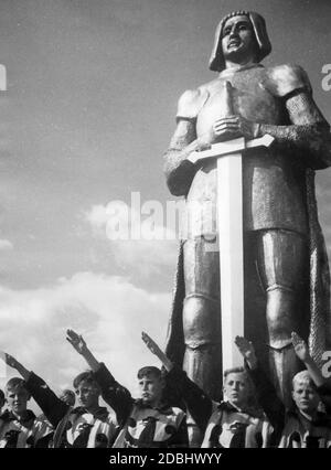 "Gli studenti di dodici anni (vestiti da cavalieri con l'aquila imperiale sul loro petto) si salutano di fronte al monumento di un cavaliere durante il gioco del movimento "Deutscher Wille werde Licht!" Al Festival delle scuole tedesche nello stadio Grunewald di Berlino." Foto Stock