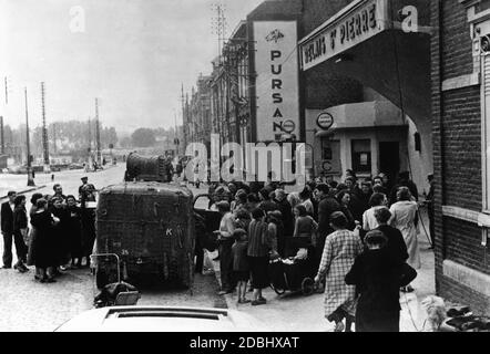 Il National Socialist People's Welfare è annunciato ad Amiens attraverso altoparlanti. Un'auto della NSV è parcheggiata su una strada di fronte a un negozio, dove si è formata una folla. Foto Stock