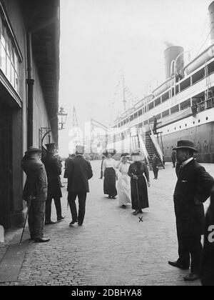 'La principessa Irene di Prussia (nee Hesse-Darmstadt, con un vestito nero al centro della foto) fu un ospite di spicco dell'ultimo Prinz-Heinrich-Fahrt nel 1911, che era stato sponsorizzato dal marito Enrico di Prussia. Qui è a Bremerhaven. Sulla destra si trova il piroscafo imperiale per posta "Grosser Kurfuerst" del Norddeutscher Lloyd, a bordo del quale Enrico di Prussia si trovava anche a Southampton durante questo viaggio." Foto Stock