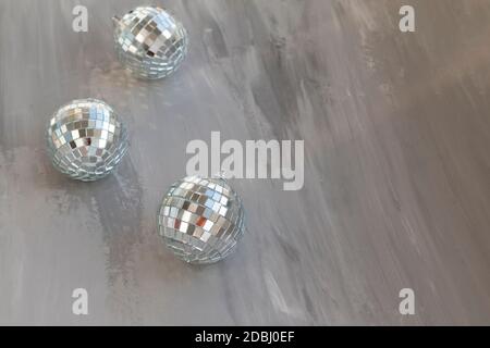 disco ball argento che riflette le luci su sfondo grigio, biglietto d'auguri per carta da parati modello con spazio vuoto per il testo Foto Stock