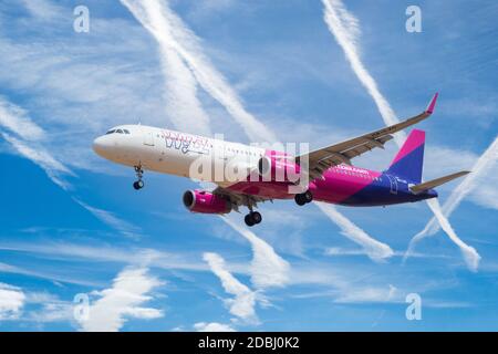 Wizz Air Airbus A321-231 con equipaggiamento di atterraggio in giù che si prepara a atterrare all'aeroporto con contracavi in cielo blu. Foto Stock