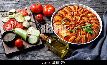 ratatouille, stufato di melanzane a fette, zucchine, cipolla e patate con salsa di pomodoro, ingredienti sullo sfondo, cucina francese, horizta Foto Stock