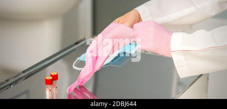 Donna dottore che indossa guanti protettivi in gomma sulle mani il laboratorio Foto Stock