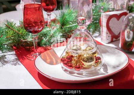 Vaso di vetro sotto forma di un albero di Natale con palle di Natale all'interno. Decorazioni natalizie per il tavolo delle vacanze. Foto Stock