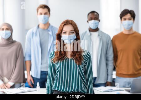 Gruppo vario di persone internazionali che indossano maschere mediche Foto Stock