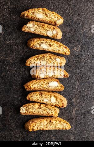 Biscotti dolci alla cantuccina. Biscotti di mandorle su tavola nera. Vista dall'alto. Foto Stock