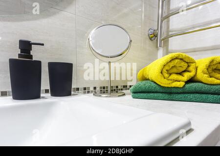 Lavello in ceramica con rubinetto con sapone nero e. distributori di shampoo in bagno costoso Foto Stock