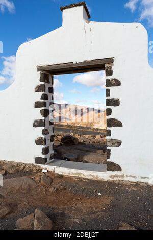 Tipico cartello comunale (cancello ad arco bianco) vicino Betancuria villaggio con deserto paesaggio di montagna sullo sfondo, Fuerteventura, Isole Canarie, S Foto Stock