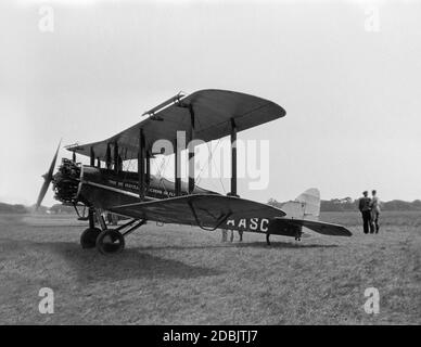 Fotografia in bianco e nero d'epoca di un aereo De Havilland DH.9J, registrazione G-AASC, appartenente alla De Havilland School of Flying, in un campo d'aviazione in Inghilterra nel 1930. Due uomini nella foto. Foto Stock