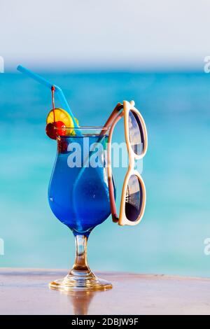 Cocktail, colorati con frutta e occhiali da sole sulla spiaggia Foto Stock